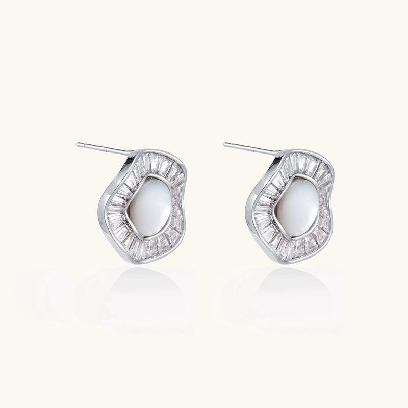 White gold-plated stud earrings with iridescent pearl centers surrounded by baguette crystal halos on white background.
