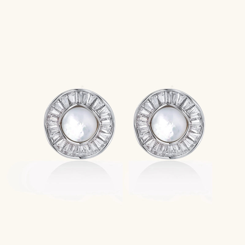 White gold-plated stud earrings with iridescent pearl centers surrounded by baguette crystal halos on white background.